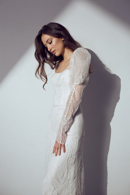 Classic lace bridal gown with detailed lace fabric, corset structure, and trailing hem