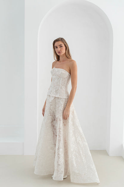 Handmade long bridal gown with hand-stitched floral appliqués, voluminous flowing skirt, and optional mini lace skirt for versatile evening wear