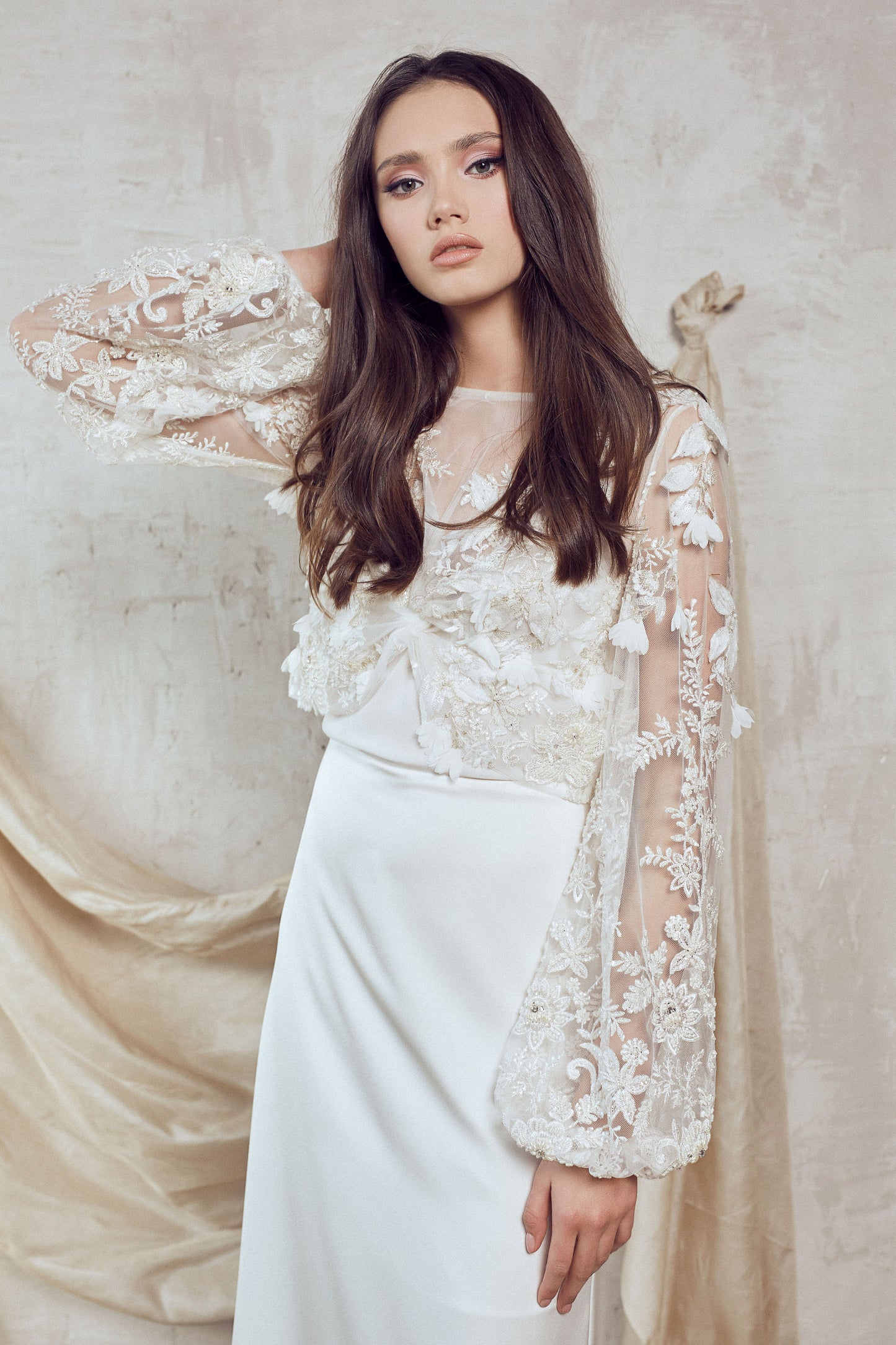 Ivory lace bridal dress with sheer long sleeve cover-up and slim bias-cut skirt with train.